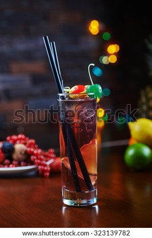 beautiful delicious alcoholic cocktail or lemonade in a glass with a backdrop of the heart with berries and Fruit on a table in a restaurant with backgrounds of bright colorful lights. soft focus.