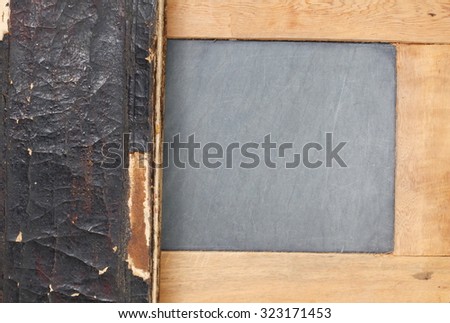 Old damaged and dirty book cover put on slate board represent the antique and book concept related idea.