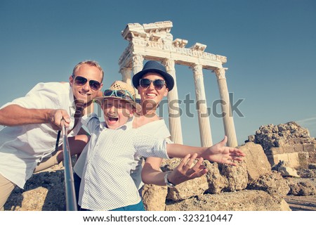 Positive young family take a selfie photo near antique colonnade