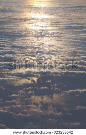 A view from the sky. An image of some clouds against the sea taken from up high. The focus point is on the sea surface. Image also has a vintage effect applied.