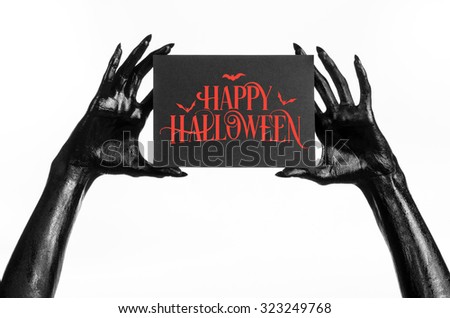 Postcard and Happy Halloween theme: black hand of death holding a paper card with the words Happy Halloween on a white isolated background in studio