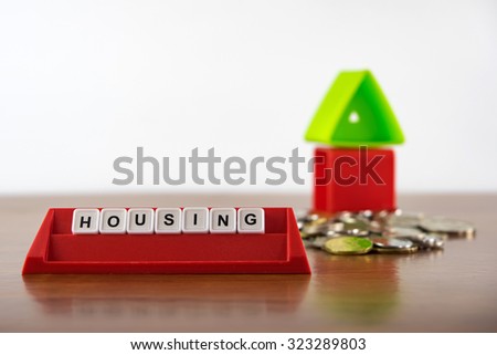 Conceptual photo of word "Housing" spelled by alphabet blocks arrangement. Selective focusing, shallow depth of field.