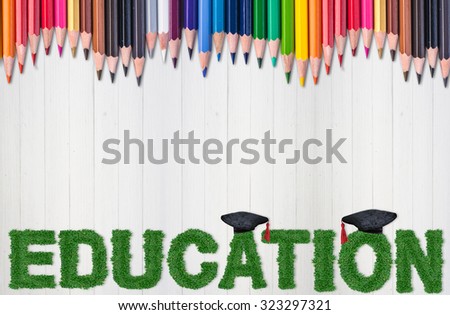 education concept. graduation background.wording education made form green grass and color pencil on white wood background.