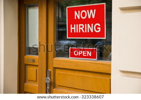 The Text Now Hiring Sticker Attached On Glass Door Of The Office