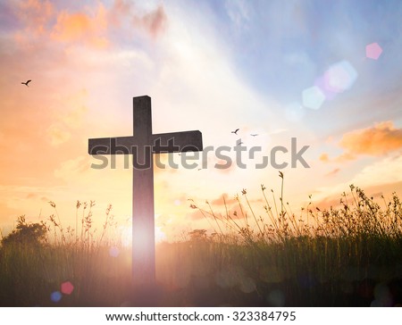 Good Friday concept: Silhouette cross of Jesus Christ on meadow autumn sunrise background
