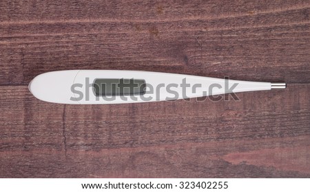 Medical thermometer over wooden background