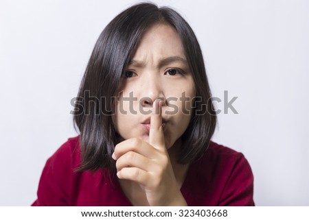 Woman saying hush be quiet on white background.