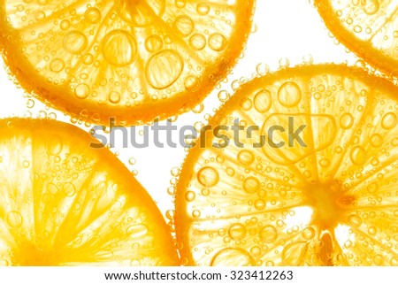 Fresh orange slice in water with bubbles on white background Royalty-Free Stock Photo #323412263