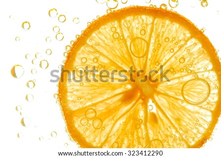 Fresh orange slice in water with bubbles on white background Royalty-Free Stock Photo #323412290