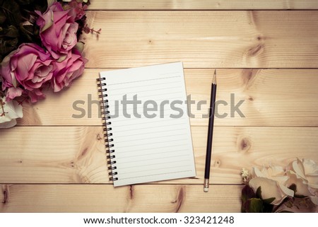 Notepad with pencil on the wood background, cross process style 