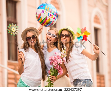 Three beautiful young women celebrating a birthday, outdoors