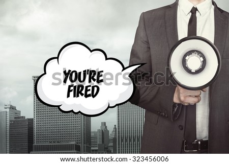 Youre fired text on speech bubble with businessman and megaphone on city background 
