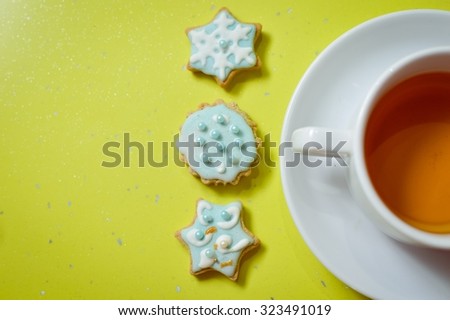 Copy space picture of handmade ginger cookies and cup of tea on green background, closeup