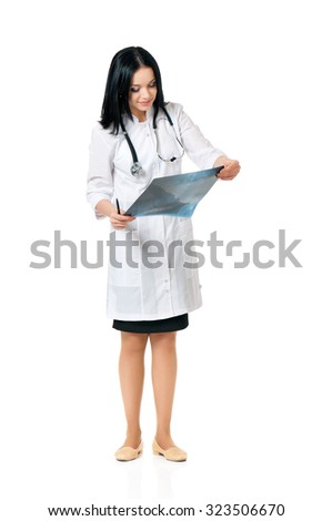 Young female doctor looking at the x-ray picture, isolated on white background 