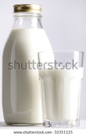 Glass and Bottle of fresh milk, selective focus, focus on the glass.