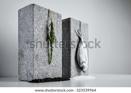 Dorada and rosemary presented on stone bricks with sea salt and black pepper