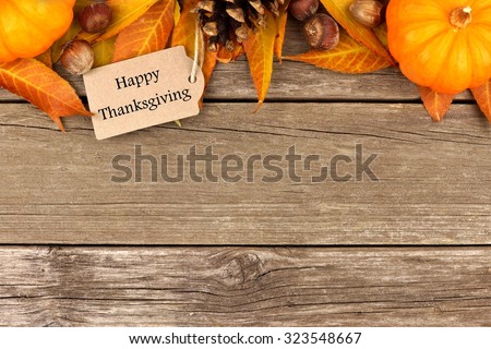 Happy Thanksgiving tag with autumn top border of pumpkins, leaves and nuts on a rustic wooden background