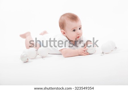 baby on a white background playing with Christmas toys, picture with depth of field