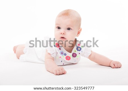 Baby girl on a white background in a smart dress, picture with depth of field