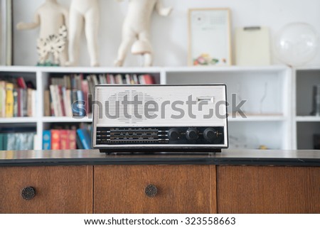 vintage radio on wooden table and bookshelf background