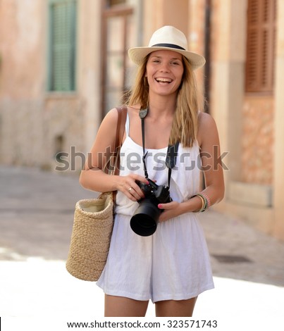 Happy woman photographer holding a dslr camera on her vacation