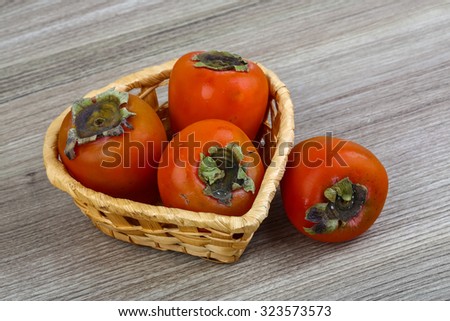 Fresh ripe juicy Persimmon fruit on the wood background