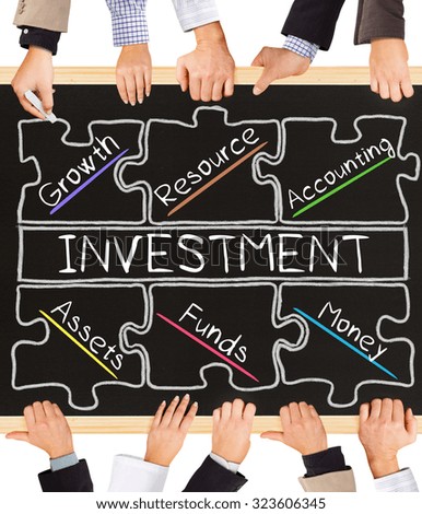 Photo of business hands holding blackboard and writing INVESTMENT diagram