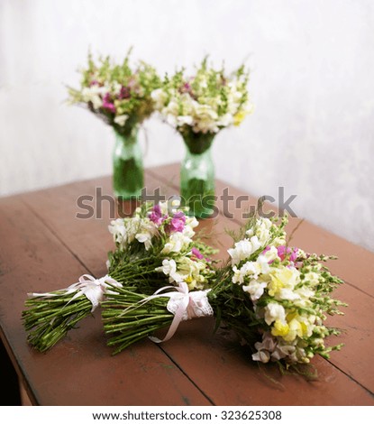 There are four handmade wedding bouquets on the table