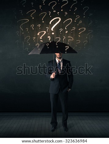 Businessman with umbrella and a lot of drawn question marks concept on background