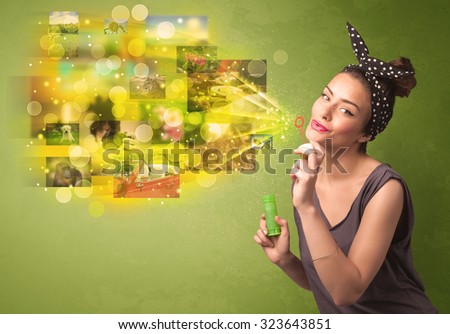 Cute girl blowing colourful glowing memory picture concept on green background