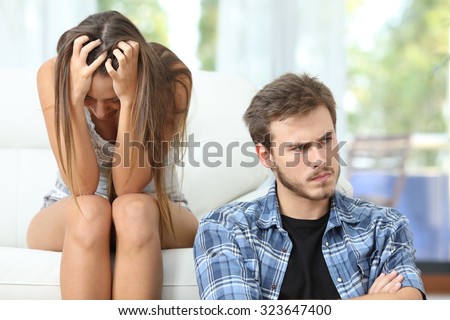 Bad relationship with a couple or marriage angry and sad after argument sitting on a couch at home Royalty-Free Stock Photo #323647400