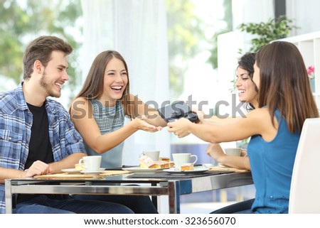 Friends celebrating birthday and giving gift to a girl sitting in a dining room