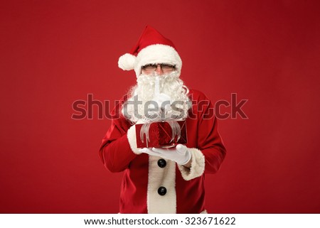 Santa Claus with a gift on a red background