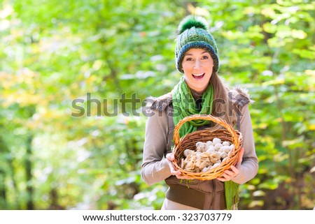 Woman with basket full of champignons in forest