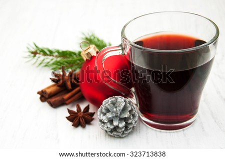 Glass of mulled wine and christmas decoration on a old wooden background