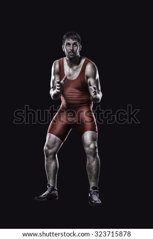 Freestyle wrestler in red uniform in ready position isolated on black background