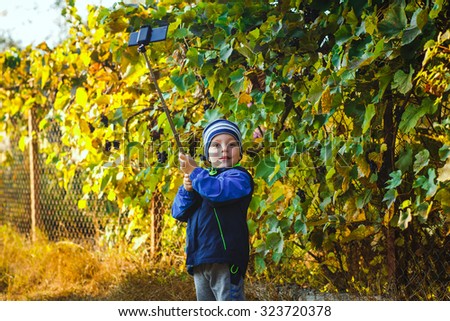 smart happy little boy taking selfie stick picture 
