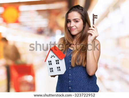 happy young woman holding a house and a key