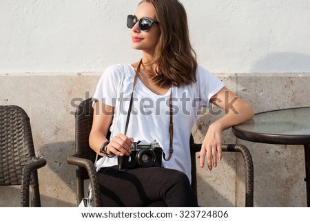 Gorgeous young brunette woman using analog camera.