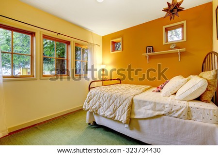 Colorful girls bedroom with an orange wall and a cozy feel.