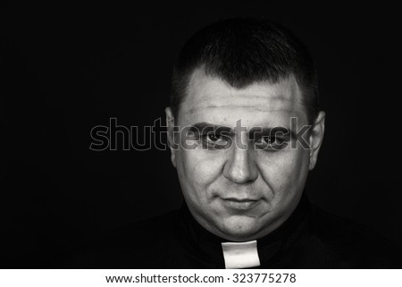  Priest on a dark background. Portrait picture of calm and reasonable man. Photo on religious themes.
