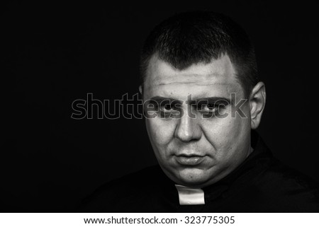  Priest on a dark background. Portrait picture of calm and reasonable man. Photo on religious themes.
