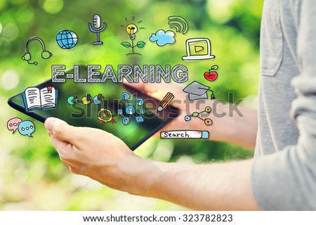 E-Learning concept with young man holding his tablet computer outside in the park 
