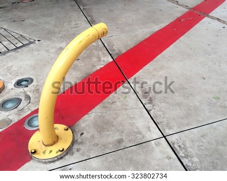 Yellow steel water pipe on cement floor ground contrast with red line