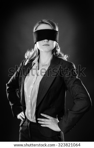 portrait of a business woman blind folded shot in the studio on gray background