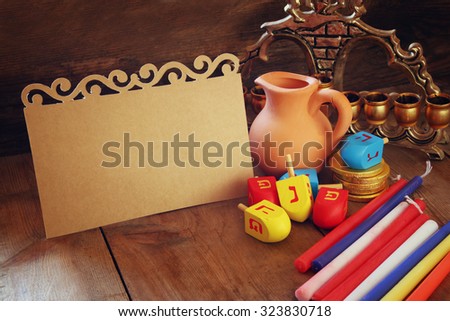 image of jewish holiday Hanukkah with menorah (traditional Candelabra) and wooden dreidels (spinning top) with empty card for adding text. retro filtered image 