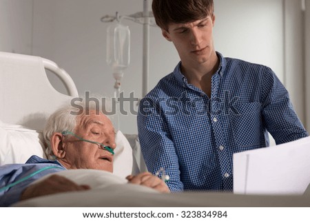 Picture of son reading his sick father medical results