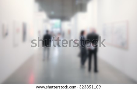 People visit exhibition art gallery, generic background. Intentionally blurred post production.