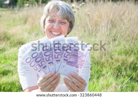 Old age woman holding a lot of money