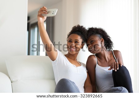 African American teenage girls taking a selfie picture with a smartphone